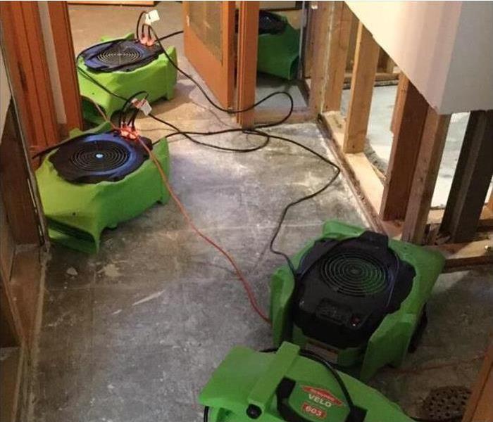 Four air movers drying out the floor that experienced flood damage after a storm